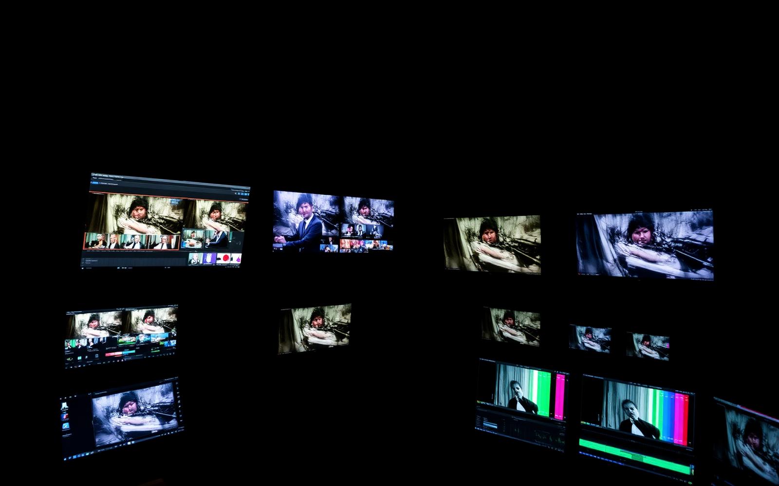 Donkere montage suite met meerdere monitoren en video timelines